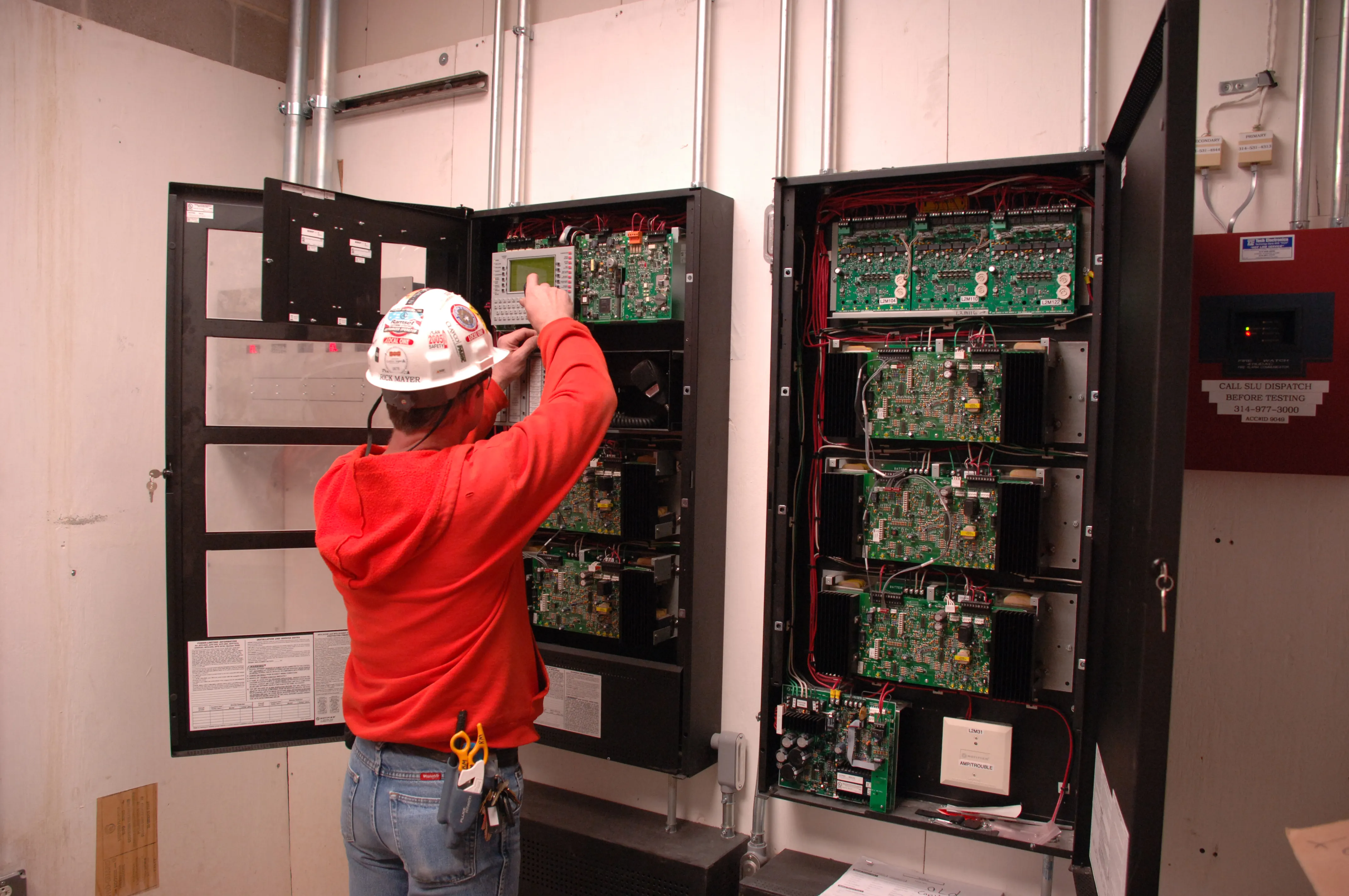 Apprentice working on a fire-alarm control panel