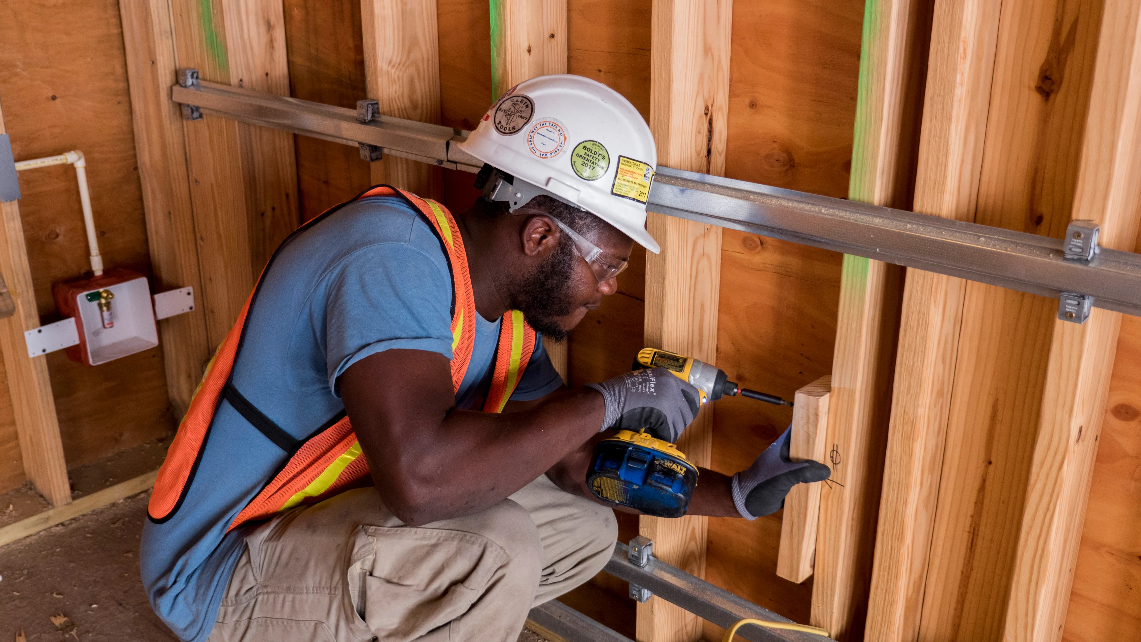 Apprentice fastening structural support in residential framing
